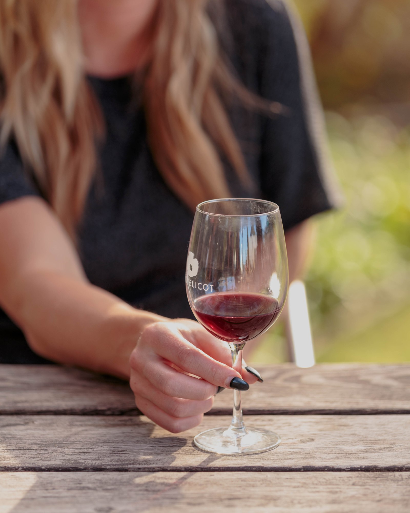 A guest holding a glass of red wine
